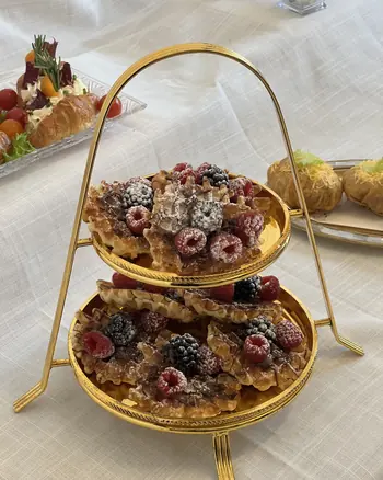 A gold heart tray of sweets and berries